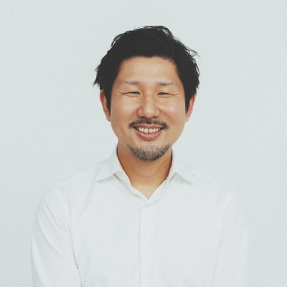 大硲 神。白いシャツ姿で、こちらを見て笑っている